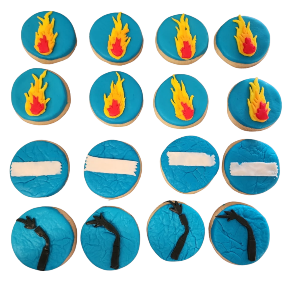Custom sugar cookies featuring hand-rolled buttercream frosing designs of campfires and starry night skies.