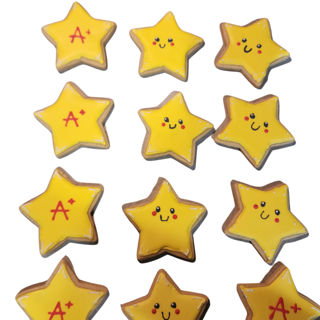 Hand-decorated star-shaped royal icing cookies featuring cute smiling faces and 'A+' grades.